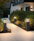 Premium Hardwired E26 Outdoor Pathway Light With Matte Black Finish And Elegant Walkway Lantern For Upgraded Yard Ambiance Plus No Fuss Zero Hassle Garden Glow Vibes illuminating a pathway with soft light.