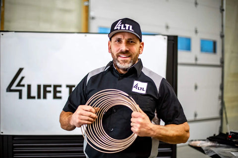 Person holding Copper Nickel Brake Line Kit Two Pack With Three Sixteenths Inch And One Quarter Inch Twenty Five Foot Tubing Coils