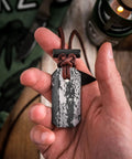 Hand holding Viking Spark Whetstone Sharpener And Fire Starter Necklace, All-In-One Survival Gear with textured design, close-up.