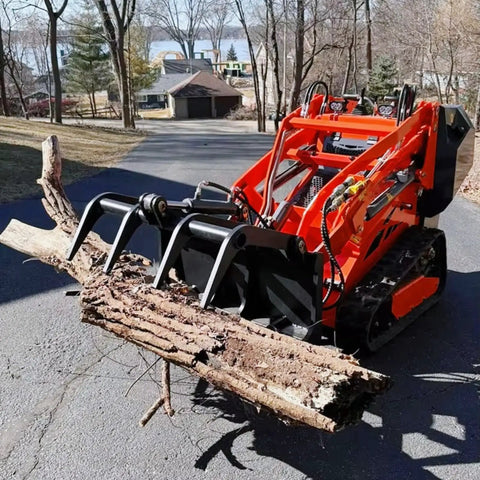 Compact 460 Mini Skid Steer Loader With Front Loader And Hydraulic Grapple Bucket Attachments holding a log on a driveway.