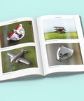 Open book displaying aircraft models for Conversions and Scratchbuilding Masterclass for Aircraft Modeling with Hands On Pro Tips.