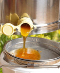 Honey flowing into Stainless Steel Honey Strainer With Double Sieve For Beekeeping Gear, Mesh Filter Screen, 9 Inch Diameter, 4 Inch Depth