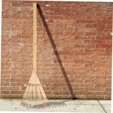 Portable Garden Hand Rake With Wear Resistant Tines leaning against brick wall