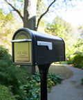 Chadwick Galvanized Steel Post Mount Mailbox Black 21 Inch with steel reinforced opening and cast aluminum handle in garden setting