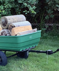 Dumping Lawn And Garden Utility Trailer With 6.5 Cubic Foot Poly Tray, 600 Lb Load, tow behind mower hauling logs on grass