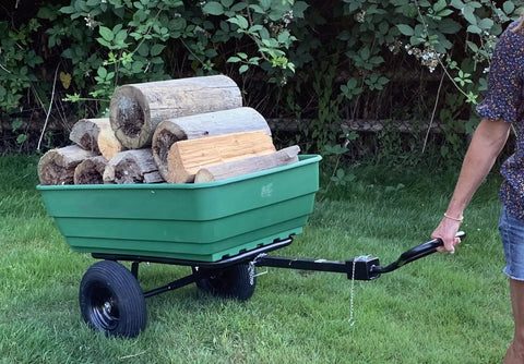 Dumping Lawn And Garden Utility Trailer With 6.5 Cubic Foot Poly Tray, 600 Lb Load, tow behind mower hauling logs on grass