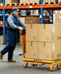 CAMMOO foldable hydraulic lift table cart, yellow, 500-lb capacity, transporting stacked cardboard boxes.