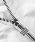 Close-up of Heavy Duty Metal Zipper Pull Tabs For Backpack Repair Silver Replacement Sliders on white fabric.