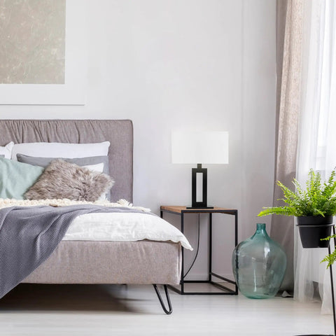 D'Alessio Table Lamp In Matte Black With Modern Cutout Body And White Linen Shade, 20 Inch Tall in a stylish bedroom setting