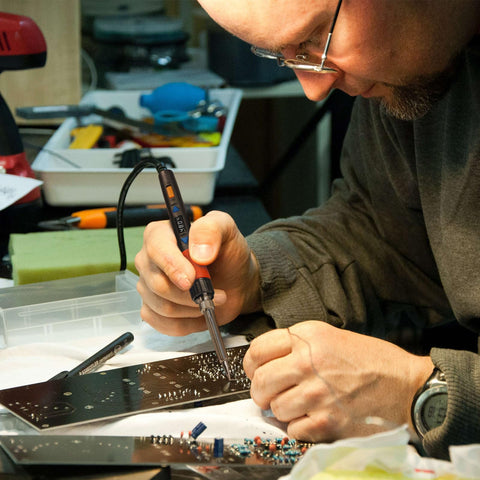 Person using 110W Soldering Iron With Full Digital Display And Temperature Control on electronic circuit board