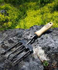 Rugged Twister Tine Hand Fork With Hardened Boron Steel, Heat Treated For Strength, on rock with FSC ash handle, made in Holland.