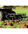 Heavy Duty Atv UTV S Tine Cultivator attached to ATV, breaking compacted soil with six plow points in a grassy field.