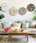 Beginner Embroidery Kit With 4 Learning Stages And 38 Stitches displayed on living room wall over sofa.