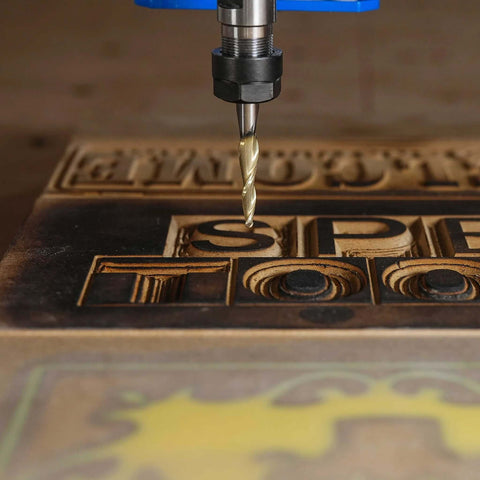 SpeTool tapered ball nose end mill, 1/4 inch shank, 1/64 inch radius, ZrN coated, installed above carved wood letters.