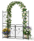87 Inch Metal Garden Arch With Lockable Gate And Side Shelves Built Tough Arbor Trellis For Climbing Plants Outdoors Includes 6 Ground Stakes Decorative Entrance Archway For Patio And Lawn Black adorned with flowers