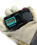 Gloved hand holding Pocket Size Digital Multimeter DMM Multi Tester For Amp Ohm Volt DC AC Voltage and Current Measurements