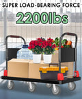 Heavy Duty 2200 Lb Platform Truck With Six Smooth Glide Wheels And Foldable Dual Handrails For Hauling Construction Tools And Warehouse Stock Without Breaking A Sweat, loaded with boxes and plants.