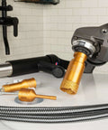 Diamond hole saw bit installed on an angle grinder; orange/gold core drill with textured tip and spare bits nearby.