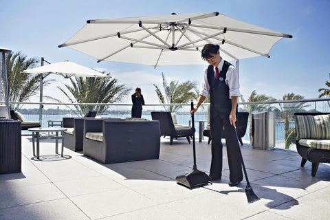 Person using Heavy Duty Dustpan With Long Handle And Pivoting Pan For Easy Debris Dumping In Lobby Restaurant Office And Home Use Black Plastic.
