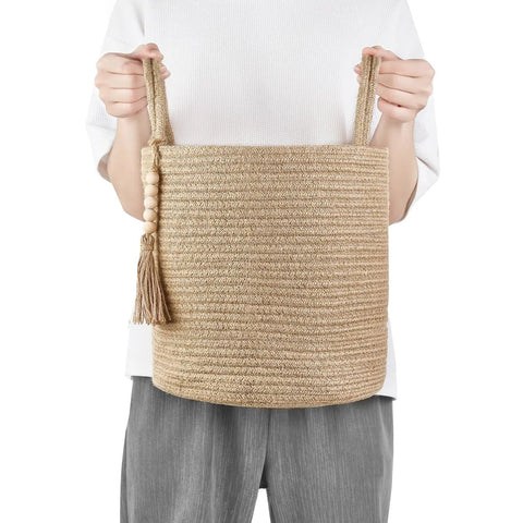 Person holding Dope Natural Rope Woven Storage Basket With Wooden Bead Handles Macrame Organizer For Blankets, Toys, Clothes, Shoes And Plants Indoor Home Decor Bin In Brown 28x28 Cm.