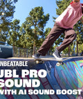 Hardest Hitting Portable Waterproof Speaker With Pro Sound And AI Boost at a skate park with skateboarder in the background.