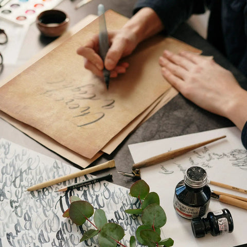 Old School Vintage Letter Paper Pack With 60 Sheets used for calligraphy with ink, brushes, and design tools on table