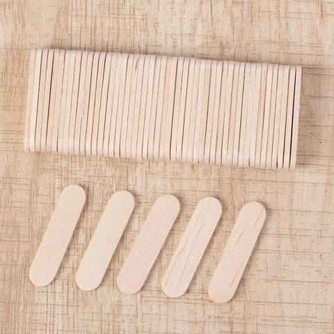 Top Shelf Food Safe Mini Popsicle Sticks For Crafting Great Treats Natural Untreated Wood Popsicle Poles laid out on a textured background.