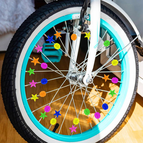 Close-up of bike wheel with colorful 72 piece bike spoke beads set with assorted shapes and colors in a handy storage box for wheel decorations
