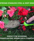 Stainless Steel Garden Scoop Trowel Transplanter With Ergonomic Grip digging soil next to red flowers.