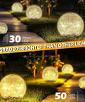 Outdoor Solar Globe Lights With 50 LED Crackled Glass Orbs Waterproof No Wiring Ground Lights illuminating a garden path.