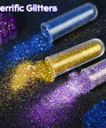 Close-up of blue, gold, and purple glitter spilling from tubes labeled "Terrific Glitters" on a dark background.
