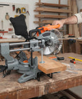 Professional Grade 10 Inch Sliding Compound Miter Saw Fueled By A Boss 15 Amp Motor cutting a wooden plank on a workbench.