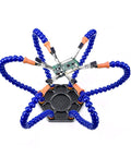 Top view of blue six-arm soldering station with rotating alligator clips holding a circuit board for electronics assembly