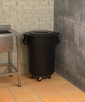 55 Gallon Black Round Commercial Trash Can With Lid And Dolly Built Tough Heavy Duty Food Grade NSF Certified Perfect For Restaurant Office School Garage Backyard Workshop Warehouse Durable Nesting Design in kitchen corner next to sink