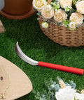 2 Pack Harvest Sickle With Plastic Handles on grass next to a basket, garden knife for lawn and yard maintenance, orange handle