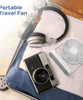 Suitcase interior with Magnetic Cruise Ship Desk Fan USB C Powered Portable With Strong Magnetic Base 3 Speed Quiet Operation Adjustable 140 Degree Tilt Ideal For Cruises Office Home Travel, headphones, and camera.