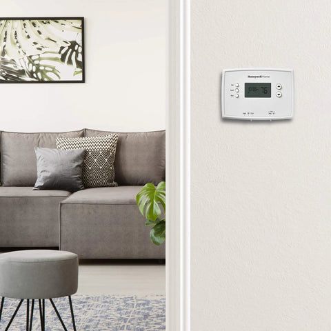 Programmable Thermostat With One Week Programming And Digital Display White on wall in living room view