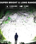 Rechargeable Spotlight 2,000,000 Lumens LED Flashlight Handheld with Cob Light illuminating a cliff at night.