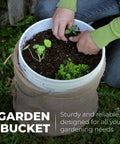 Person using Beefy 5 Gallon Food Grade Bucket With Lid Heavy Duty 90 Mil Pail Metal Handles With Plastic Grip Multi Use Storage BPA Free Stackable For Easy Stacking And Storing 6 Pack for gardening.