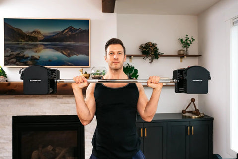 Man lifting Pro Series Straight Bar For Adjustable Dumbbells Turns Your Home Gym Into A Badass Barbell Setup Expands Weightlifting Curling And Strength Training Options Compatible With Pro Series Dumbbells in living room