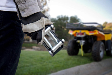Person holding a Roller Fairlead For 3500 Lb And Under ATV UTV Winches With Stainless Steel Rollers and black frame outdoors.