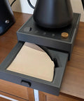 Game Changing Two In One Coffee Station Organizer With Heavy Duty Kettle Stand And V60 Paper Filter Bin showing a V60 filter bin drawer with papers on a countertop.