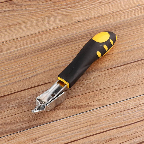 Kickass Heavy Duty Nail Puller And Staple Remover With Comfortable Dual Rubber Grip Handle for upholstery repair on wooden surface.