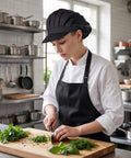Top Shelf Three Pack Chef Hats For Women And Men With Brimmed Elastic Fit Breathable Poly Cotton Kitchen Cooking Caps For Restaurant Shifts And Weekend Cookouts in a kitchen, chef cutting herbs.