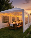 Spacious 10x30 Outdoor Party Tent Canopy For Weddings Backyard BBQs And Events With 8 Removable Sidewalls at sunset, decorated with lights.