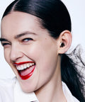 Person wearing Experience 2 Plus Ear Plugs For Concerts And Festivals With 17 dB Noise Reduction, smiling, close-up view.