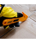 Concealed Blade Safety Knife With Protected Blade For Tape Slitting And Packaging Tasks 4mm Throat Delivers Continual Safe Blade Exposure And Easy One Hand Use For Shipping Warehousing And DIY Jobs, gloved hand cutting cardboard