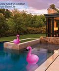 Solar Flamingo Floating Pool Lights 4 Pack, Solar Powered LED Flamingo Lights in modern backyard pool at sunset glowing pink
