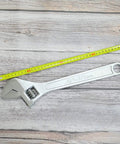 15 Inch Adjustable Wrench With 45mm Jaw Opening For Heavy Duty Garage And DIY Projects next to a measuring tape on wood surface