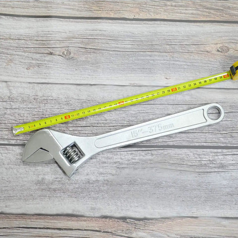 15 Inch Adjustable Wrench With 45mm Jaw Opening For Heavy Duty Garage And DIY Projects next to a measuring tape on wood surface